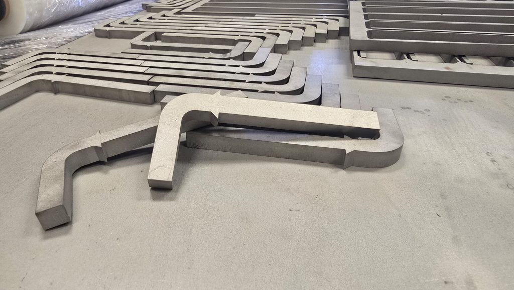 Waterjet cutting a nested plate, with the jet splash on the sheet